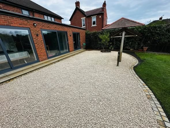 A finished garden with new fencing, gravel and a pergola