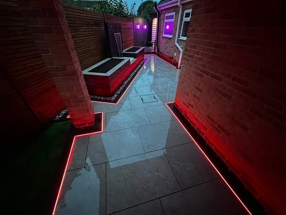 A garden lit in red LED light at night