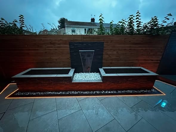 A porcelain garden with a lit water feature wall