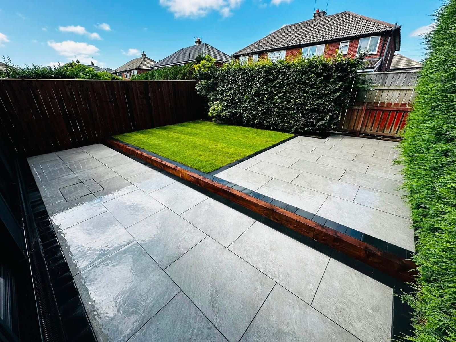 A new grey porcelain patio beside a freshly laid lawn